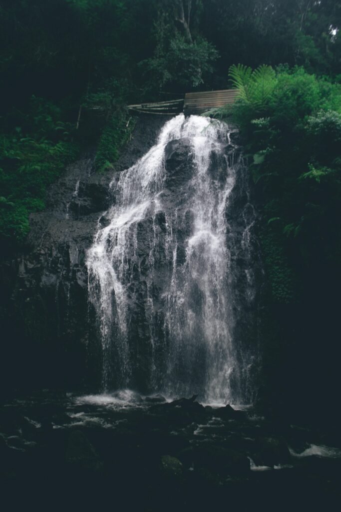 Experience the serene beauty of a waterfall surrounded by lush rainforest in Bandung, Indonesia.